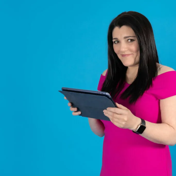 Tracy holding her ipad AI Marketing: Tracy looking up from her ipad whilst contemplating AI